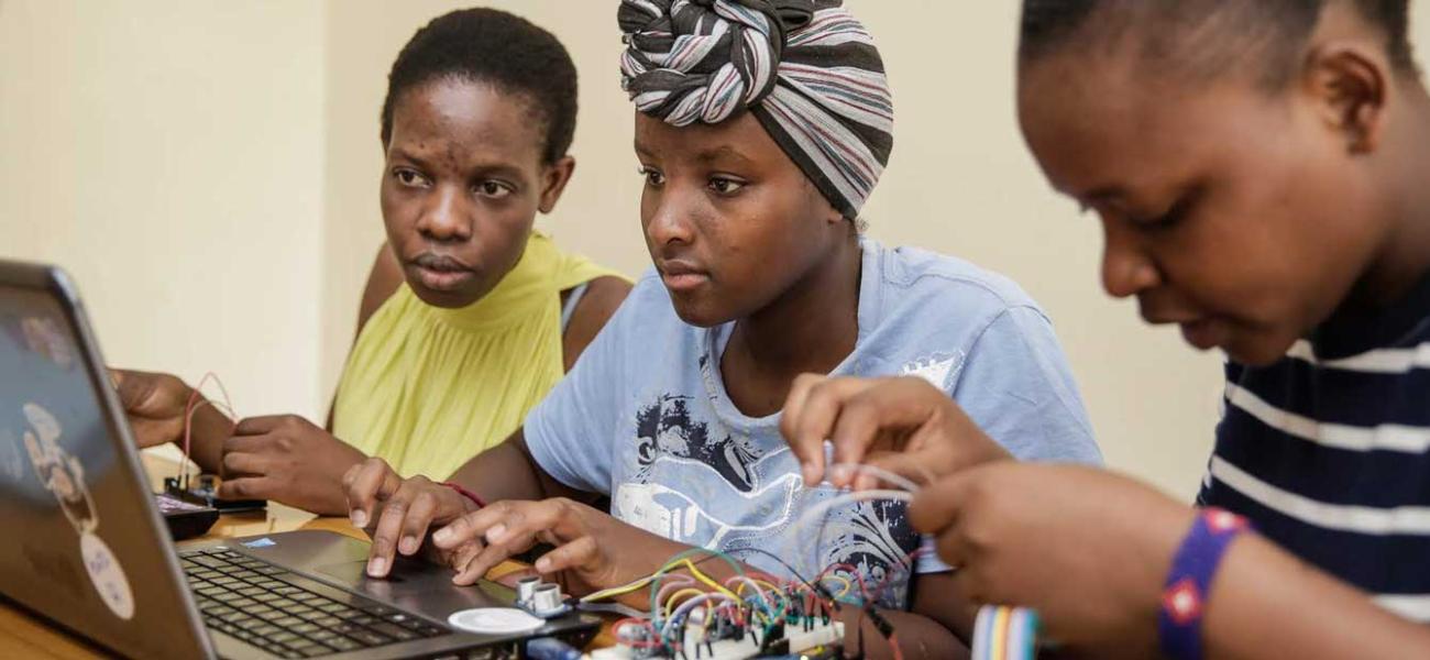 Young women in AkiraChix hardware and electronics class build circuit boards.