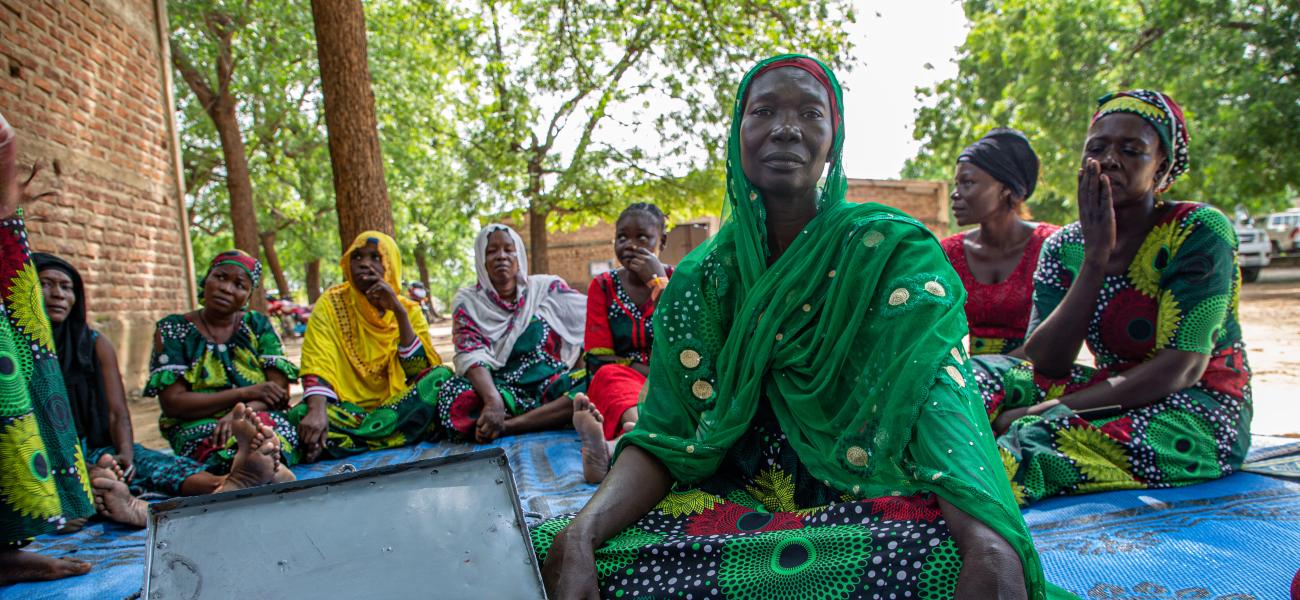 Zara Ellie, a dedicated mother and entrepreneur, leading the 'Hanoune' Savings and Internal Lending Community meeting in Koudoul, Chad, where members unite to foster financial growth and solidarity.