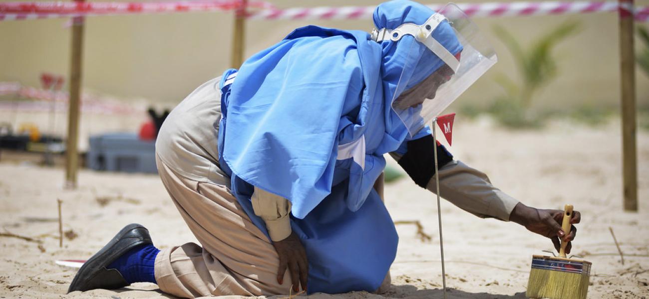 A member of an Explosive Ordnance Disposal team brushes sand off a mortar shell during a demonstration held by the United Nations Mine Action Service (UNMAS) in Mogadishu, Somalia.