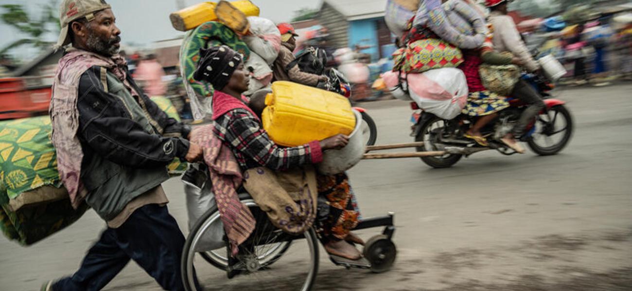 Residents of the Kanyaruchinya camp near Goma flee on Sunday - fighting has overwhelmed the capital of North Kivu province.