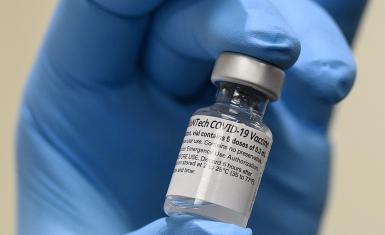 Army Spc. Angel Laureano holds a vial of the COVID-19 vaccine. Photo: Lisa Ferdinando