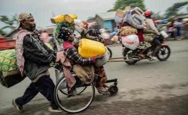 Residents of the Kanyaruchinya camp near Goma flee on Sunday - fighting has overwhelmed the capital of North Kivu province.