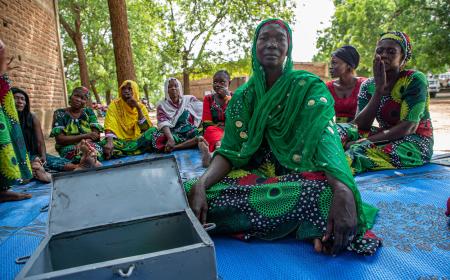 Zara Ellie, mama na mjasiriamali aliyejitolea, akiongoza mkutano wa Jumuiya ya Akiba na Ukopeshaji wa Ndani ya 'Hanoune' huko Koudoul, Chad, ambapo wanachama huungana ili kukuza ukuaji wa kifedha na mshikamano.
