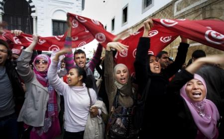 Agitating for change: Women wave flags during a demonstration in Kasbah Square, Tunis.     Photo: Panos / Alfredo D’Amato