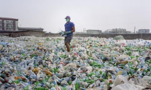 A man sorting a sea of plastic bottles at one of the Wecycler hubs in Lagos, Nigeria. Most plastic litter from cities ends up in oceans.