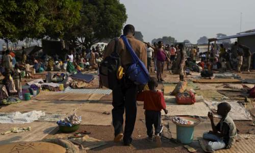 A man and his child walk through a crowded site for internally displaced people in the Central African Republic capital, Bangui, where many people remain at risk. Photo: UNHCR/S. Phelps