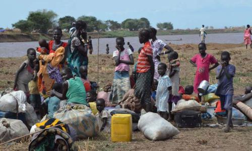 A group of displaced women and children rest on Ethiopian territory after crossing the Baro River from South Sudan. Photo: UNHCR/L.F. Godinho