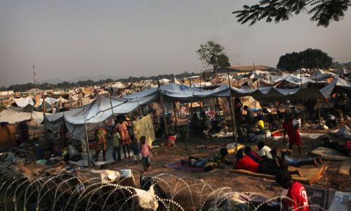 Des enfants et des adultes déplacés dans un camp derrière l’aéroport de Bangui, en République centrafricaine (RCA). 