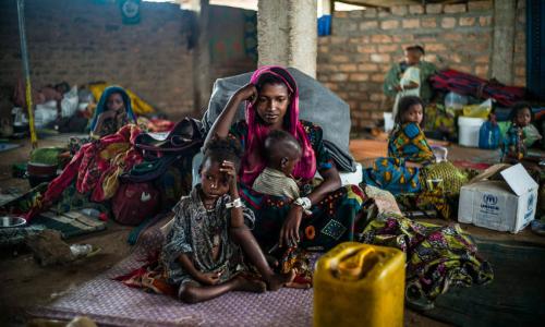 Hajara, 19, and her children await their first hot meal in over two months. They arrived in Dosseye refugee camp the previous day after fleeing violence in Central African Republic. UNHCR/C.Fohlen