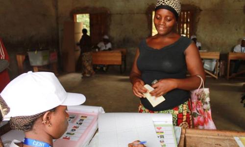 An electoral worker checks names against the voters' list at a polling station during elections in Burundi. Photo: MENUB