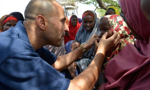 World Health Organization (WHO) official, Dr. Ahmed El Ganainy, checks the eyes of a little girl during a joint humanitarian assessment mission to Marka, Somalia, on 9 July 2014. UN Photo/David Mutua