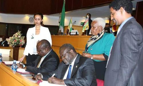 Former South Sudan Vice President Riek Machar (seated right) and Pagan Amum Okiech, representing the Former Detainees, sign the compromise peace agreement put forth by the Intergovernmental Authority on Development Partners Forum (IGAD) mediation in Addis