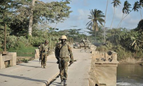 Ugandan soldiers serving with the African Union Mission in Somalia (AMISOM), walk across a bridge near the town of Janaale, Somalia.