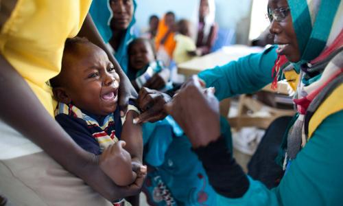 A child receives a vaccination against meningitis at the community centre in Al Neem camp for Internally Displaced People in El Daein, East Darfur, Sudan. Photo: UNAMID/Albert González Farran