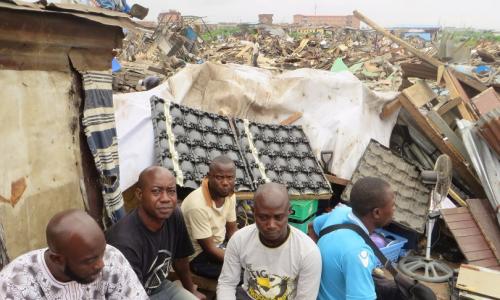 Des personnes devant les ruines de leurs maisons démolies dans le quartier de Badia, à Lagos, en octobre 2015.