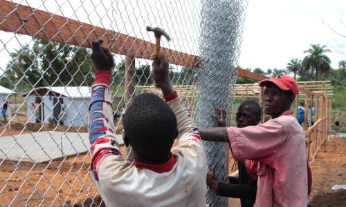 Workers build an enclosure at the Mayagba Ebola community care centre construction site in Bombali District, which is among the areas worst affected by the disease in Sierra Leone. Photo: UNICEF/John James