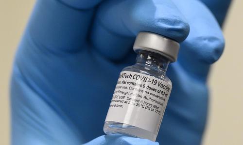 Army Spc. Angel Laureano holds a vial of the COVID-19 vaccine. Photo: Lisa Ferdinando