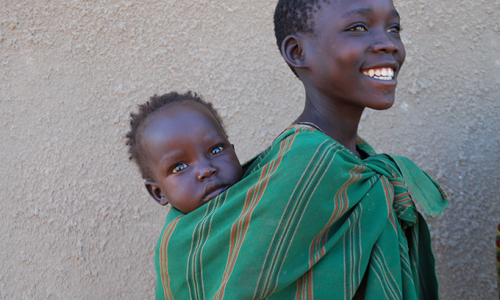 Woman carrying child on back.