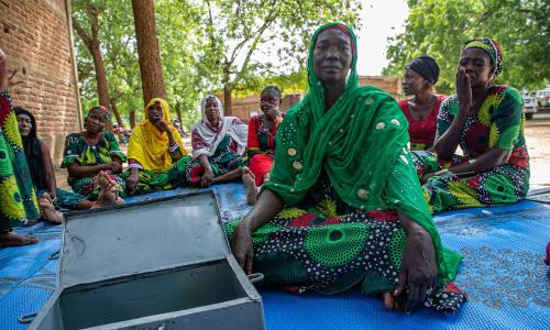 Zara Ellie, mama na mjasiriamali aliyejitolea, akiongoza mkutano wa Jumuiya ya Akiba na Ukopeshaji wa Ndani ya 'Hanoune' huko Koudoul, Chad, ambapo wanachama huungana ili kukuza ukuaji wa kifedha na mshikamano.