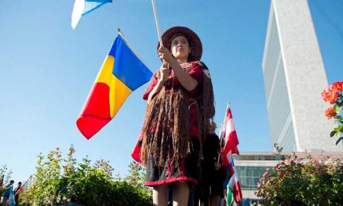 A young girl carrying the flag of a Member State of the United Nations during the annual Peace Bell Ceremony held at UN headquarters in observance of the International Day of Peace (file photo, 21 September 2013). UN Photo/Amanda Voisard