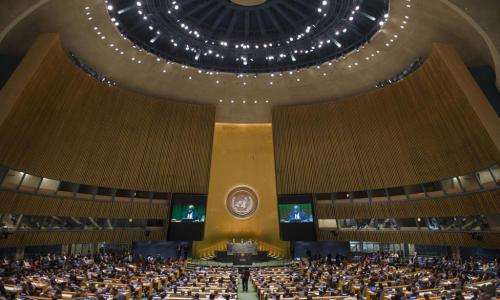 A wide view of the General Assembly Hall as President of the 69th session of the Assembly, Sam Kahamba Kutesa (on screens), makes his opening address. UN Photo/Amanda Voisard
