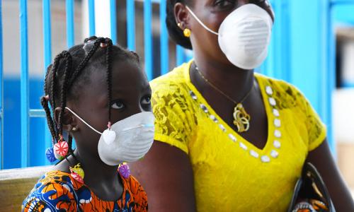 Mama na bintiye wakiwa wamevaa barakoa kujilinda dhidi ya virusi vya corona katika kituo cha afya Abidjan, Côte d'Ivoire.