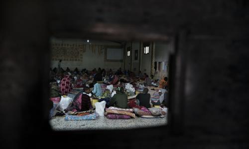 Taswira kupitia dirisha la chuma ikionyesha mazingira ya wahamiaji waliolala kwenye magodoro sakafuni kwenye moja ya vituo vya kushikilia wahamiaji nchini Libya