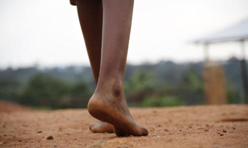 On 29 May, Centia, 12, walks barefoot across dusty ground in Kirundo Province, Burundi. Photo credit: UNICEF/UNI186074/Nijimbere