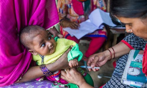 Mkunga awapa chanjo dhidi ya polio Mama na mtoto wake mchanga.
