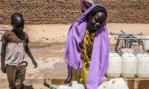 Wakimbizi wa ndani jimbo la Darfur Sudan wanakabiliwa na changamoto nyingi na ugumu wa kupata maji safi. Pichani ni msichana na kaka yake wakiwa katika kituo cha maji safi cha Abu-Shok kwenye kambi ya wakimbizi wa ndani illi kuteka maji. Picha: Mahady