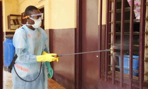 A volunteer disinfecting the hospital of Tahouay in Conakry, Guinea.  Photo: Afreecom/Idrissa Soumaré