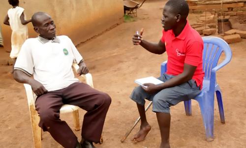 Home Health Promoter Eliaba Anthony Amba (right) speaks with Bennet Khamis.