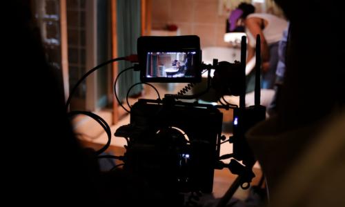 Behind the camera capturing the scene