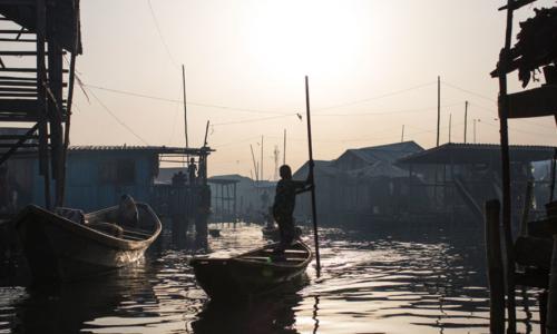 In Lagos, Nigeria, residents navigate the polluted waters of Makoko, a fishing community mostly made up of structures on stilts above Lagos Lagoon, as smog spreads throughout the canals.