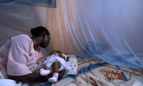 Infant surrounded by protective malaria bed net in Ghana. Photo: World Bank/Arne Hoel