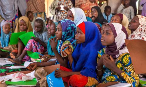 Girls use their new school supplies during a class in an informal learning centre in a UNICEF-supported safe space for children in the Dalori camp for internally displaced people, in the north-eastern city of Maiduguri in Borno State. Photo: UNICEF/UNI193