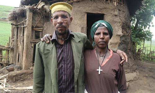 Mrs. Belay with her husband, Priest Leul Hunegnaw, in front of their barn. She says contraception has had a liberating effect.