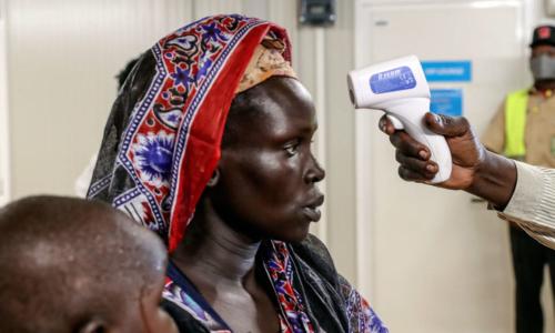 An internally displaced woman voluntarily returning to her home in Bentiu, South Sudan, is being checked for fever.