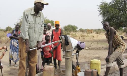 Salva Dut (left) pumps water from one of the boreholes he has helped drill in South Sudan. Photo: Water for South Sudan