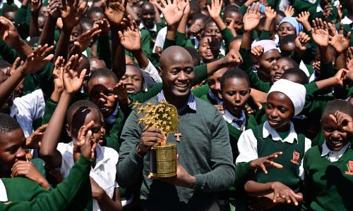 Teacher and Franciscan brother Peter Mokaya Tabichi, 36, holds his Global Teacher Award as he is cheered on by his students at Keriko Secondary School in Njoro, Nakuru county.            Getty Images/ Tony Karumba