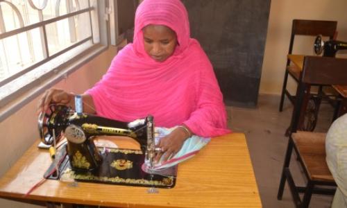 A young woman learns sewing at Soufouroulaye youth camp. The training is part of a regional programme to strengthen human security and resilience in the Sahel.