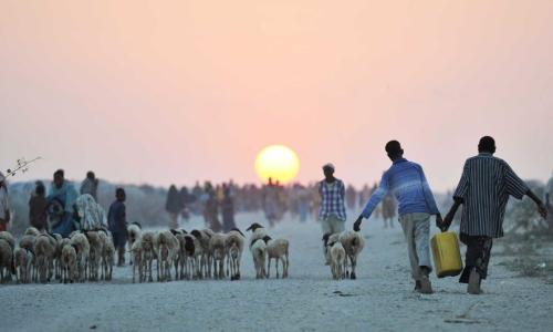 Two young boys carry water next to an camp for displaced people near the town of Jowhar, Somalia.