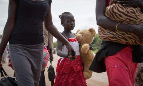 A young refugee and her family cross the border between South Sudan and Uganda. Photo: UNHCR/Will Swanson