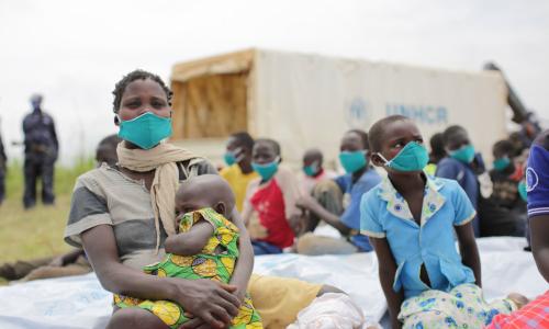 Mkimbizi mwenye umri wa miaka 29 anayetafuta hifadhi kutoka Jamhuri ya Kidemokrasia ya Congo, ameketi na watoto wake baada ya uchunguzi wa kimatibabu karibu na mpaka wa Zombo, Uganda.