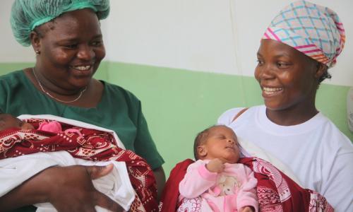 Mkunga Adelaide Raul kutoka Msumbiji akifurahi na mama baada ya kumzalisha watoto mapacha