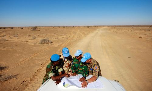 Peacekeepers with the UN Mission for the Referendum in Western Sahara (MINURSO) consult a map as they drive through vast desert areas in Smara, Western Sahara. Photo Credits:UN Photo/Martine Perret