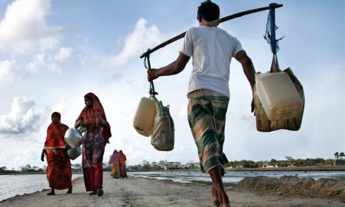 Above, people carry drinking water in Bangladesh