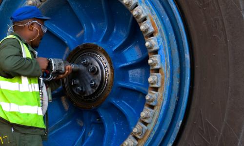 A worker repairs a wheel of a giant haul truck at a uranium mine in Namibia.