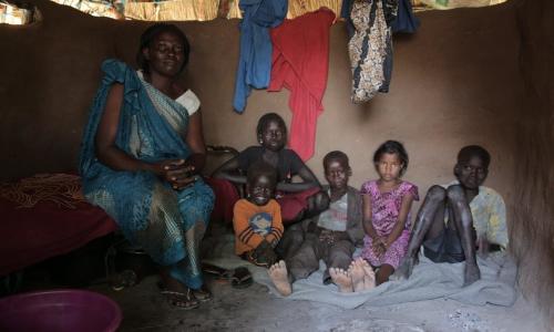 Mary Amaik and her family sit in their small house in Pibor, South Sudan.
