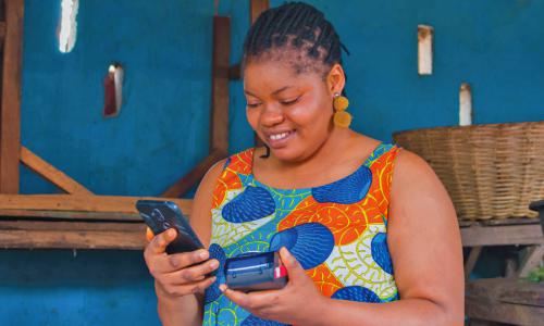 African woman entrepreneur with digital payment device.